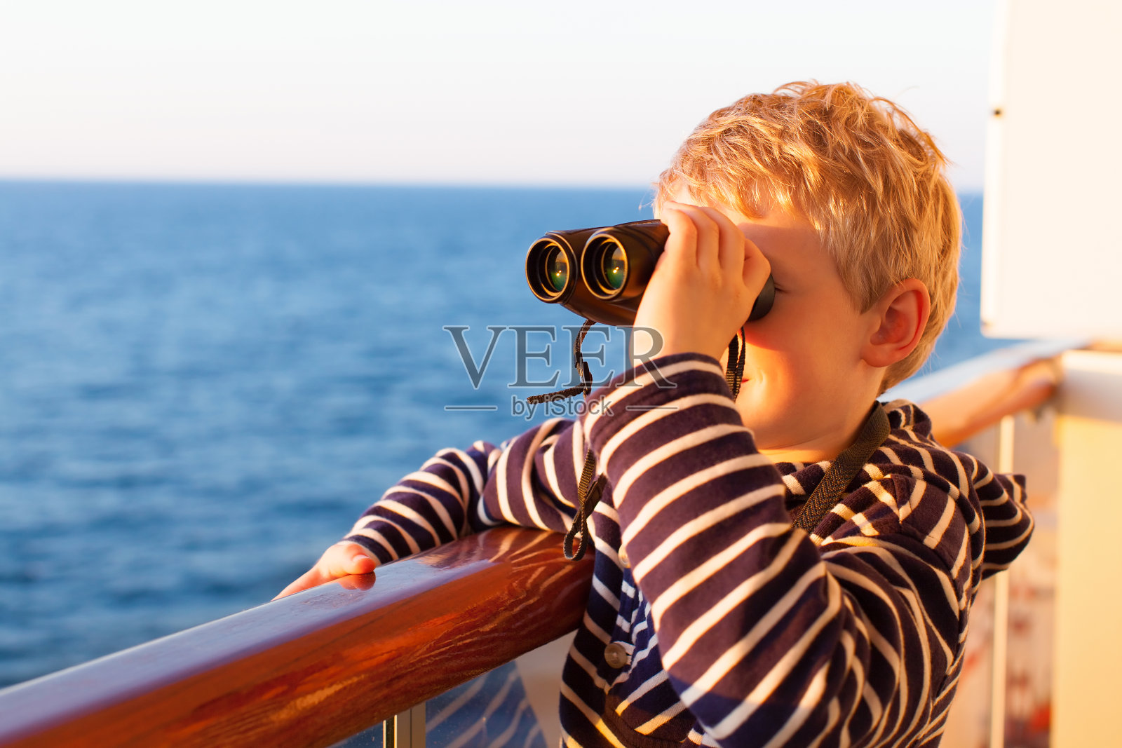 带着双筒望远镜巡航的孩子照片摄影图片