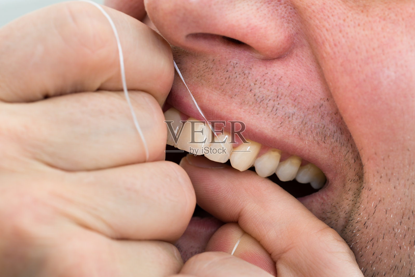 男人用牙线清洁牙齿照片摄影图片