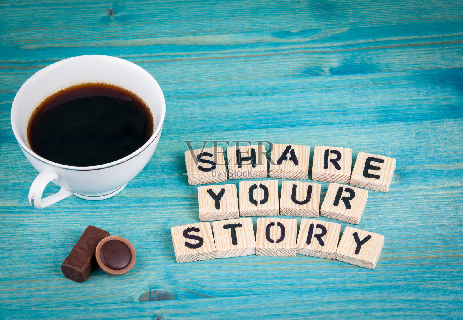 分享你的故事。咖啡杯和木头背景上的木头字母照片摄影图片