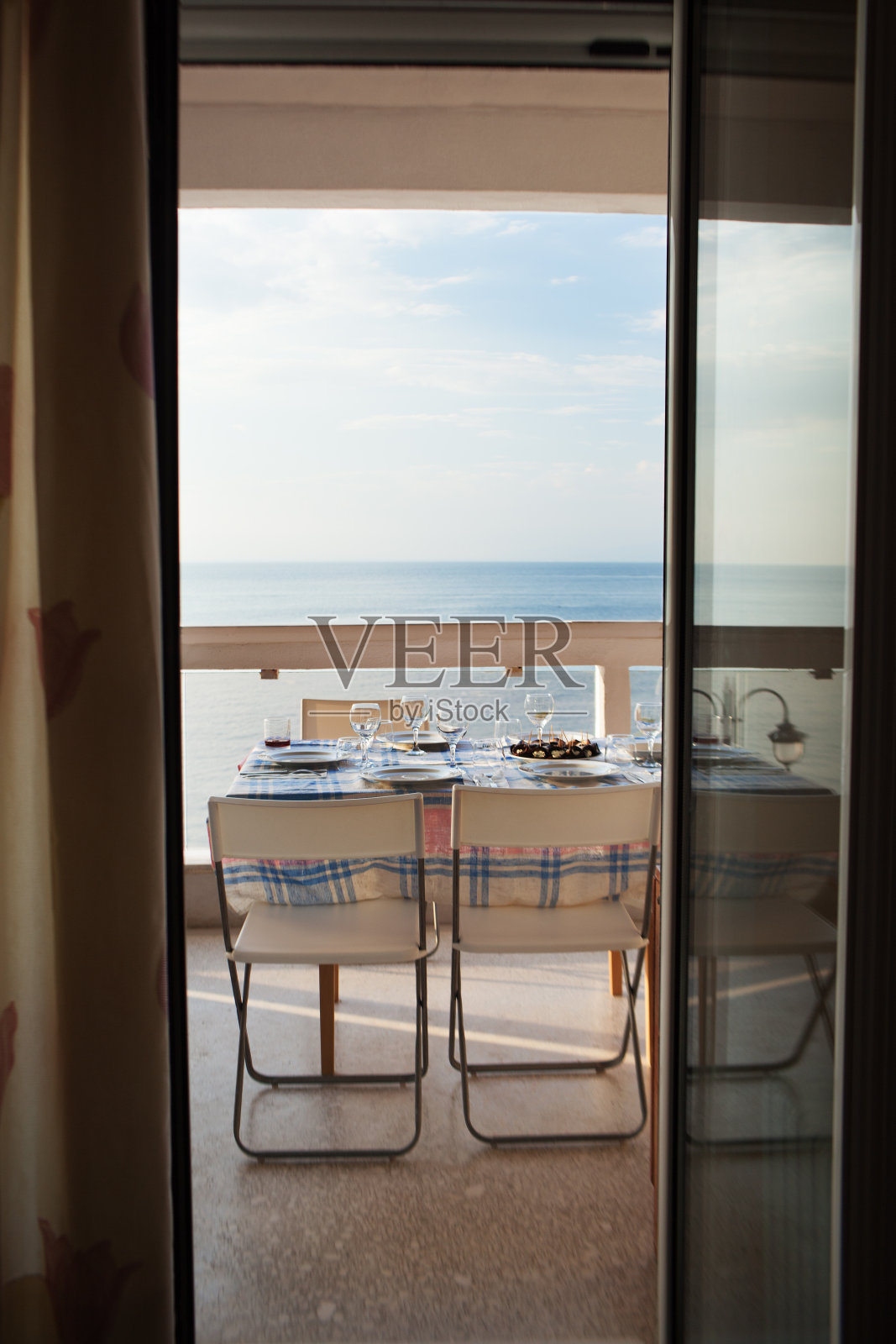 餐桌设置在阳台上俯瞰大海照片摄影图片