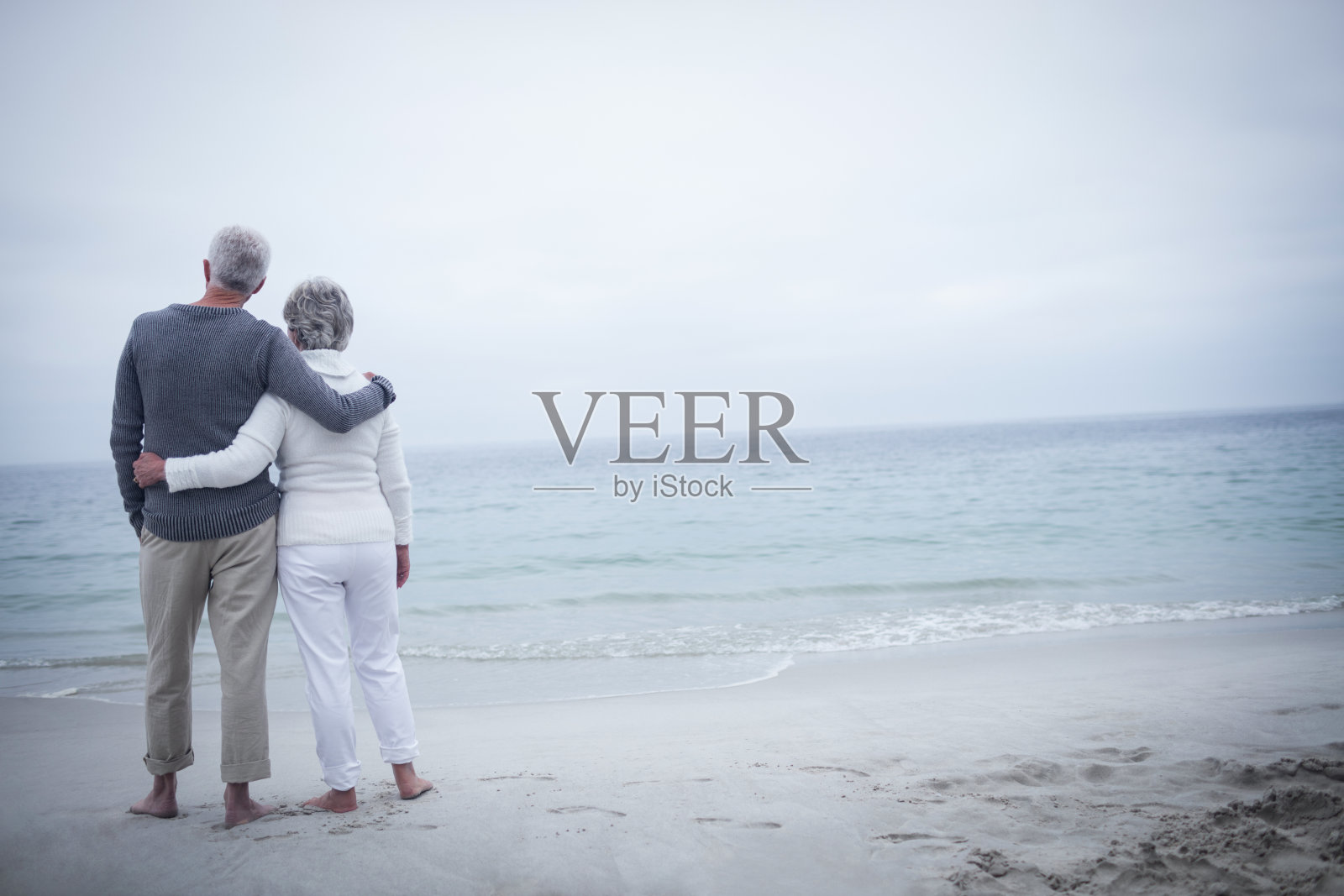 老夫妇在海滩上拥抱的后视图照片摄影图片