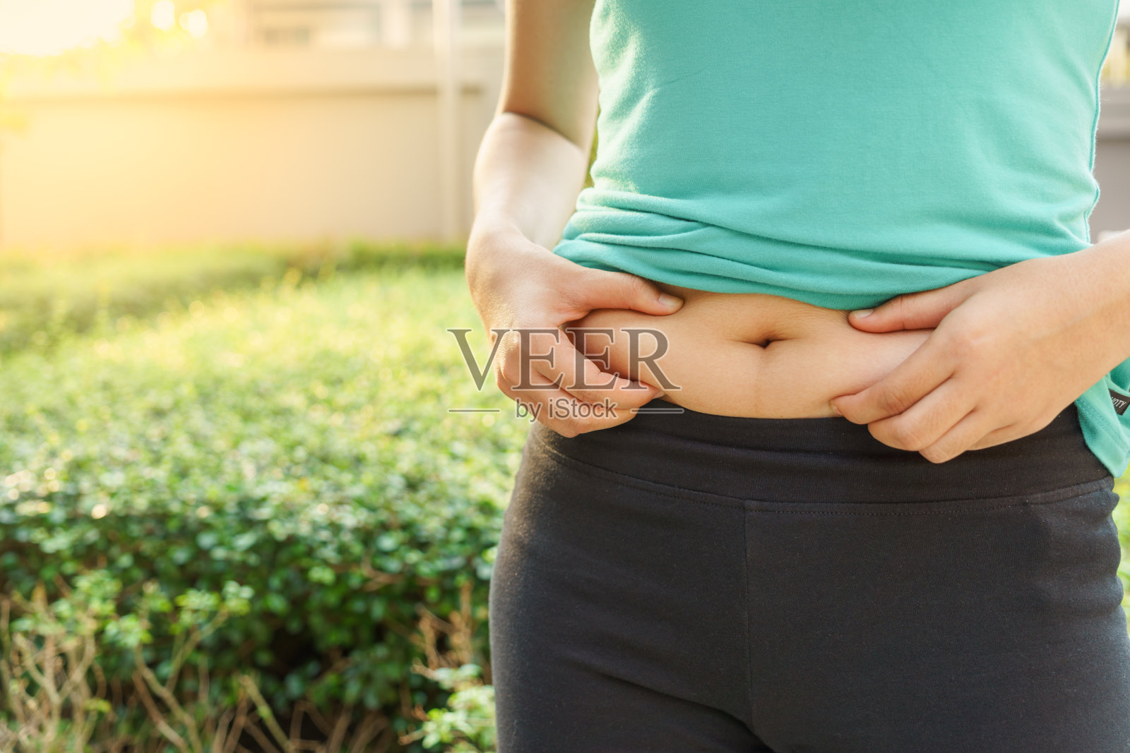 胖乎乎的女人手牵着自己的大肚子在户外照片摄影图片