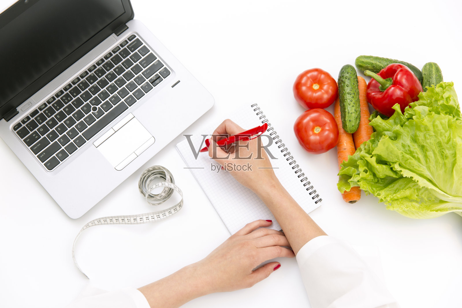 蔬菜饮食营养或药物概念。医生手写饮食计划，熟蔬菜成分，笔记本电脑和白底卷尺照片摄影图片