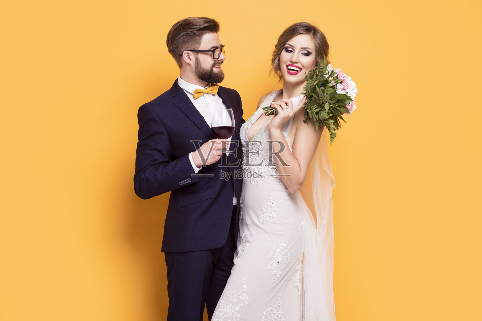 微笑着年轻的新婚在黄色的背景照片摄影图片