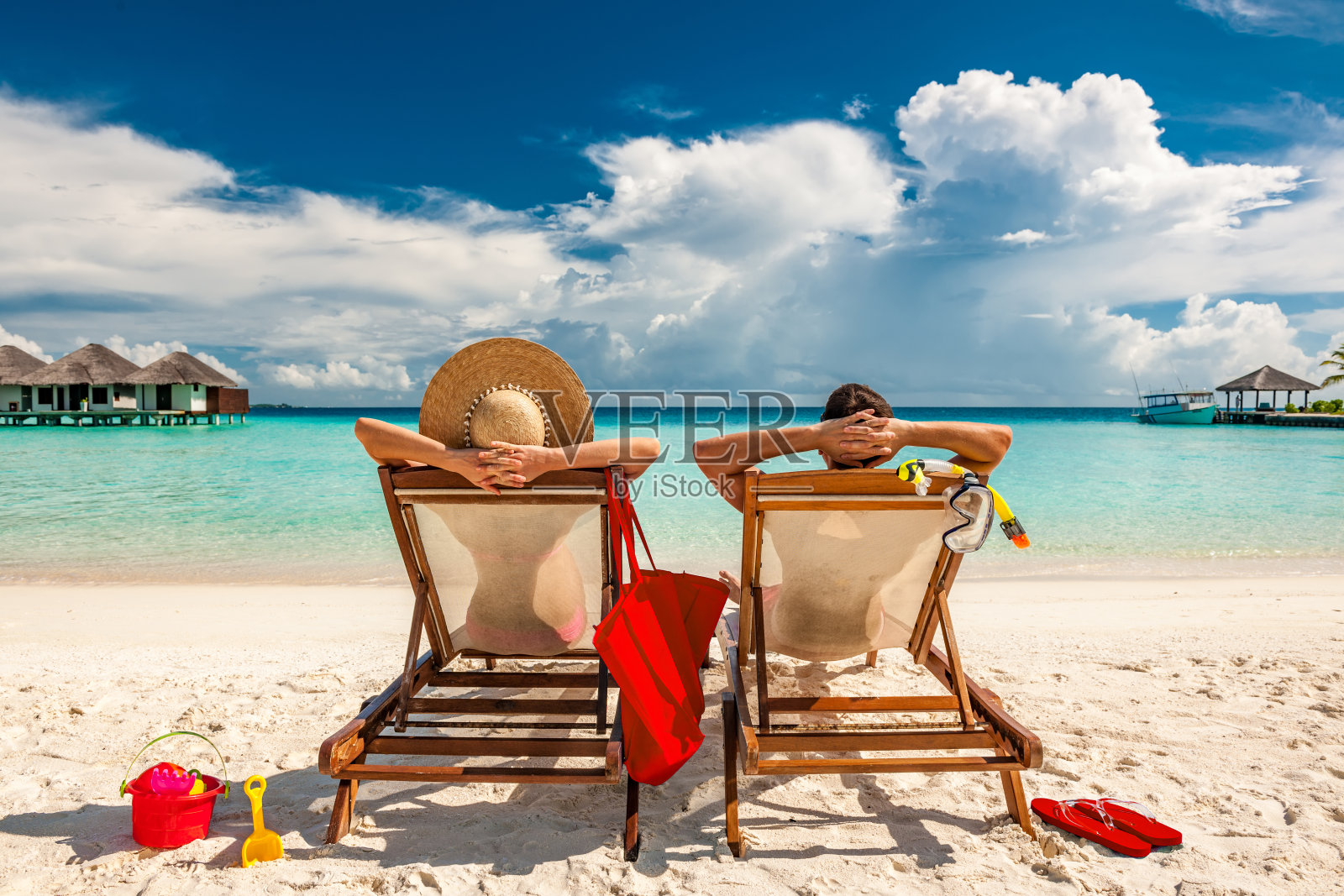马尔代夫海滩上躺在躺椅上的夫妇照片摄影图片