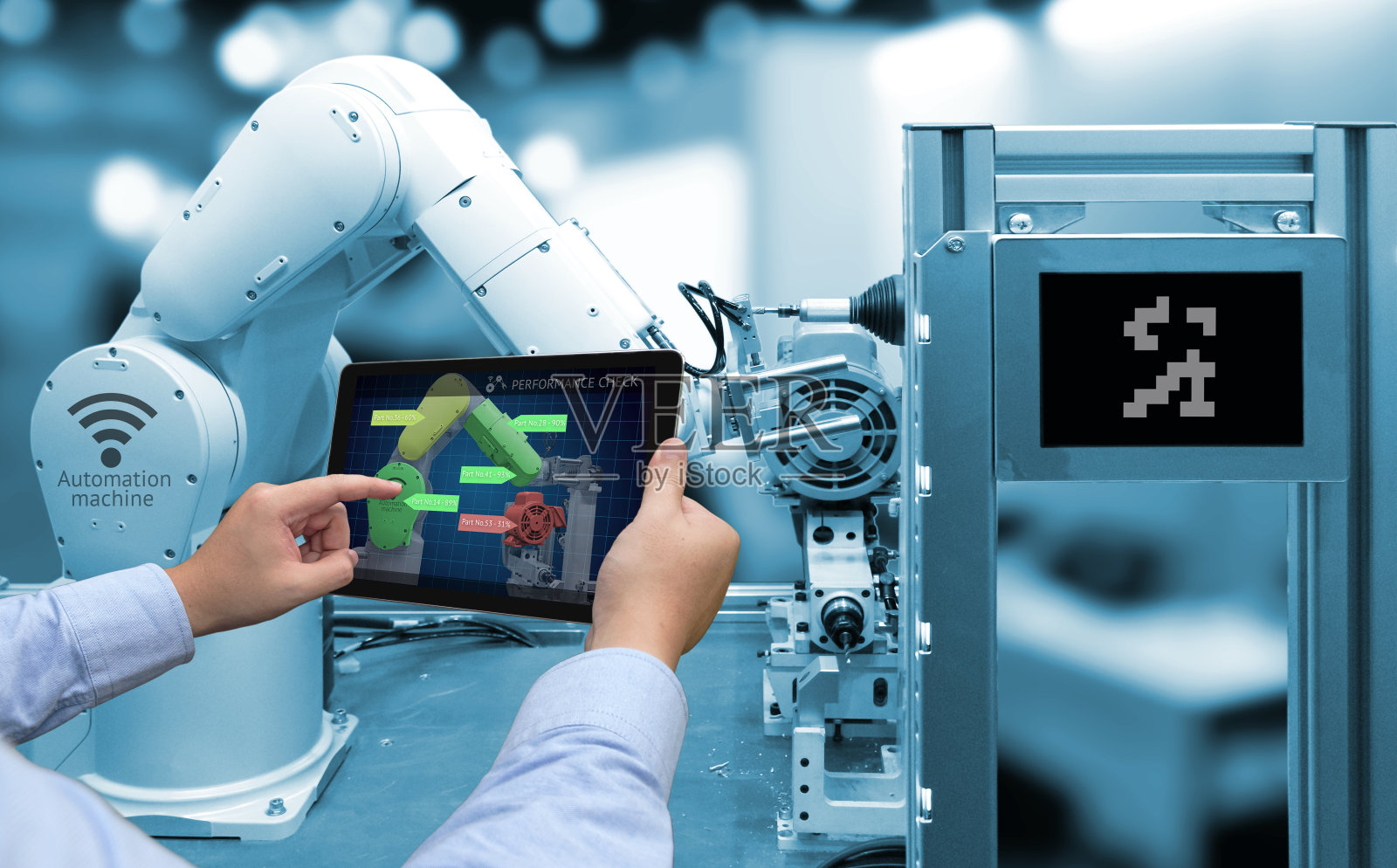 工业4.0概念。带性能检查屏幕软件的手动平板电脑和智能工厂背景下的自动化无线机器人手臂的蓝色调照片摄影图片