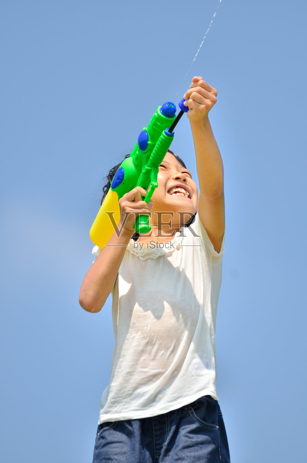 水鉄砲で遊ぶ女の子(青空)照片摄影图片