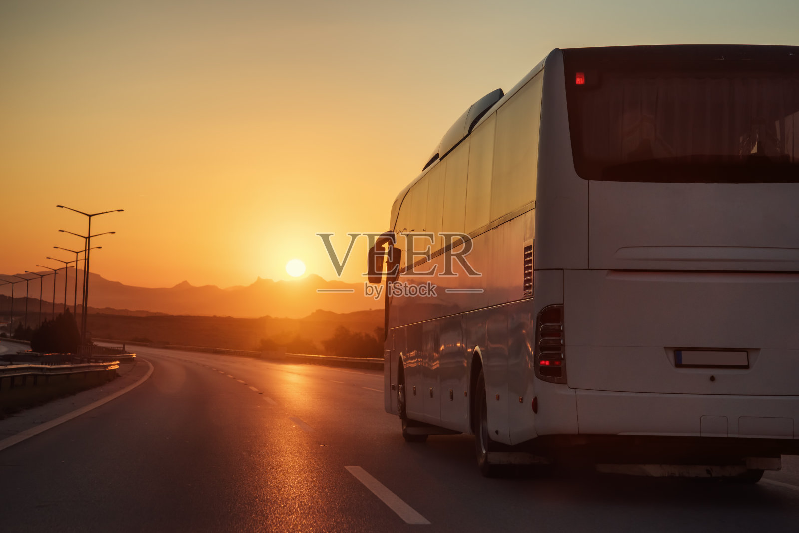 一辆白色的公共汽车朝夕阳驶去照片摄影图片
