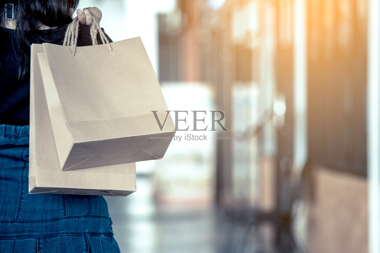 一个女人手拿购物袋在购物中心的大街上照片摄影图片