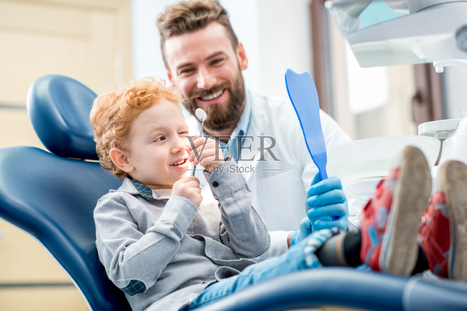 牙科诊所有个带牙医的男孩照片摄影图片
