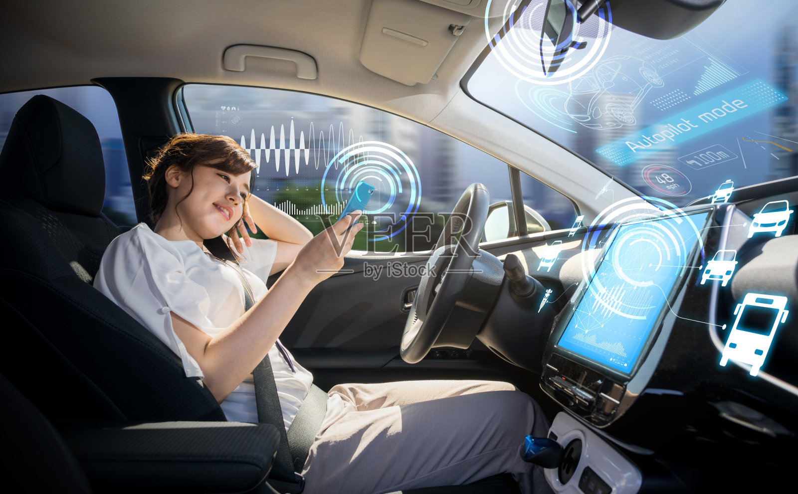女性在自动驾驶汽车上使用智能手机。自己驾驶车辆。自动驾驶仪。汽车技术。照片摄影图片