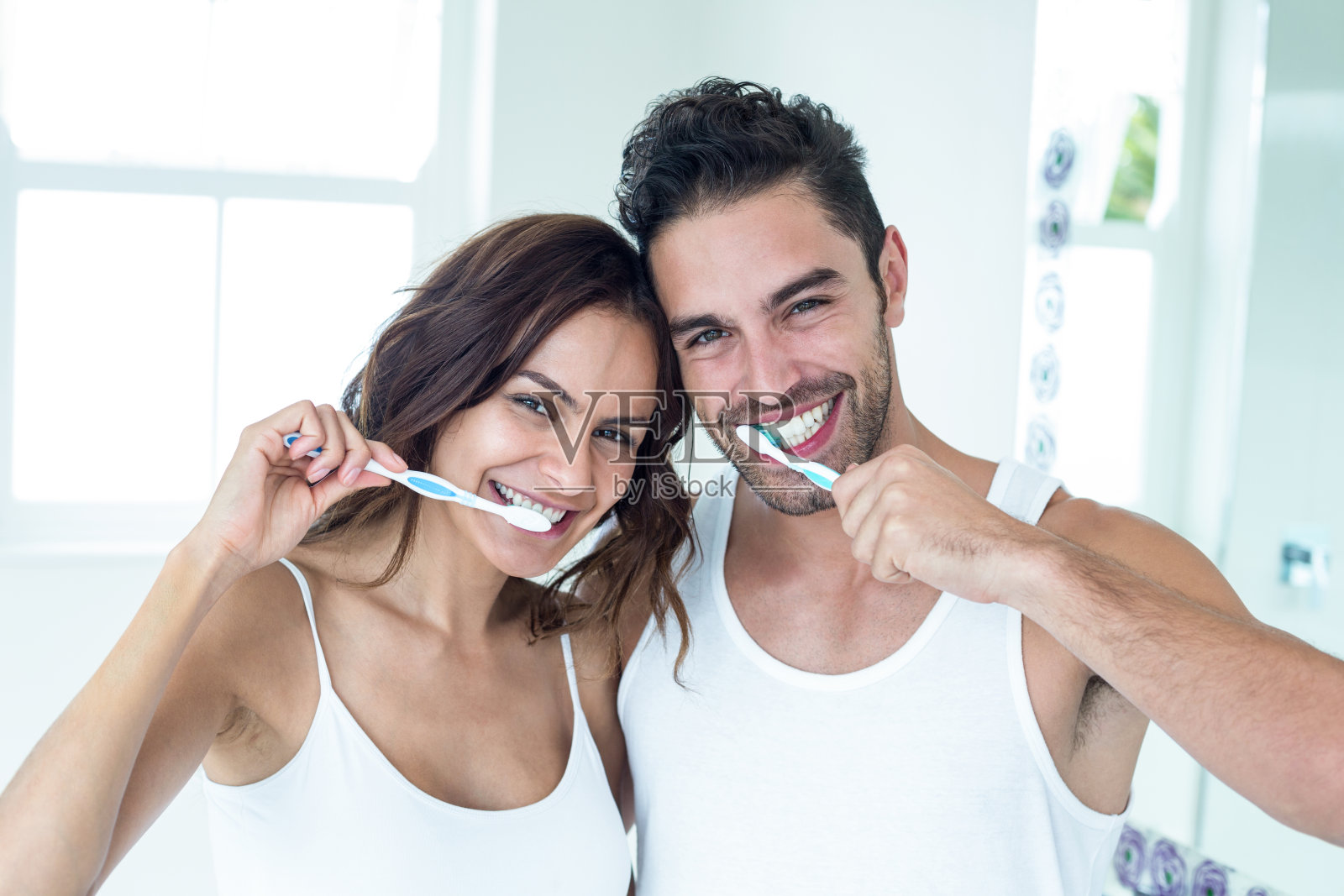 一对幸福的情侣在浴室里刷牙照片摄影图片