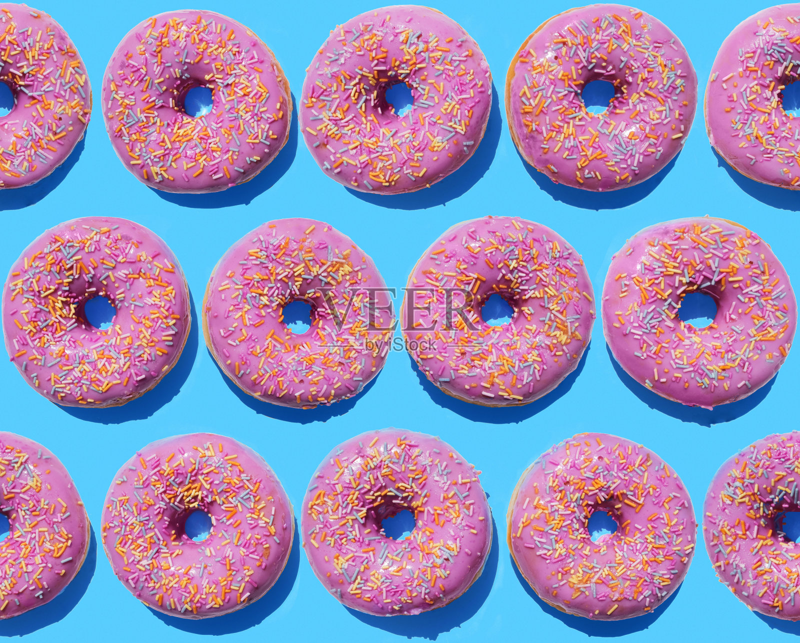 蓝色背景上的粉色环形甜甜圈设计元素图片