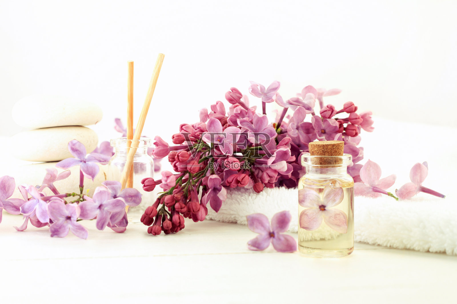 香精油瓶内置鲜花提取物，清新的淡紫色，白色的淡色调照片摄影图片