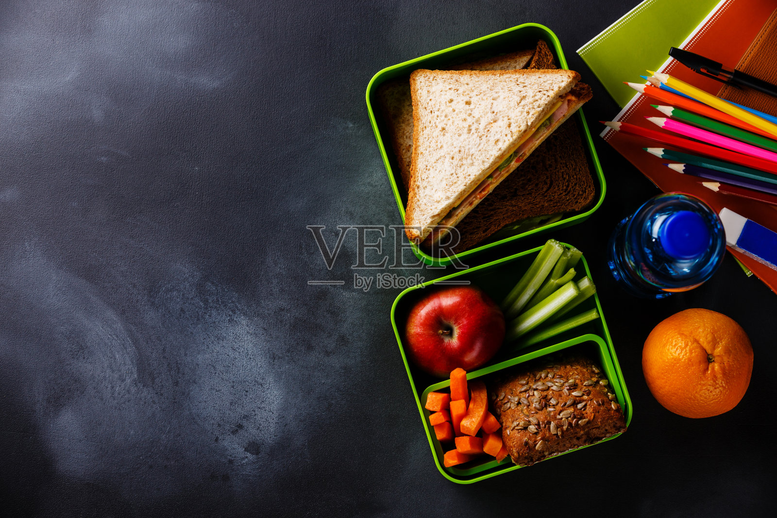 午餐盒，三明治，瓶装水和学习用品照片摄影图片