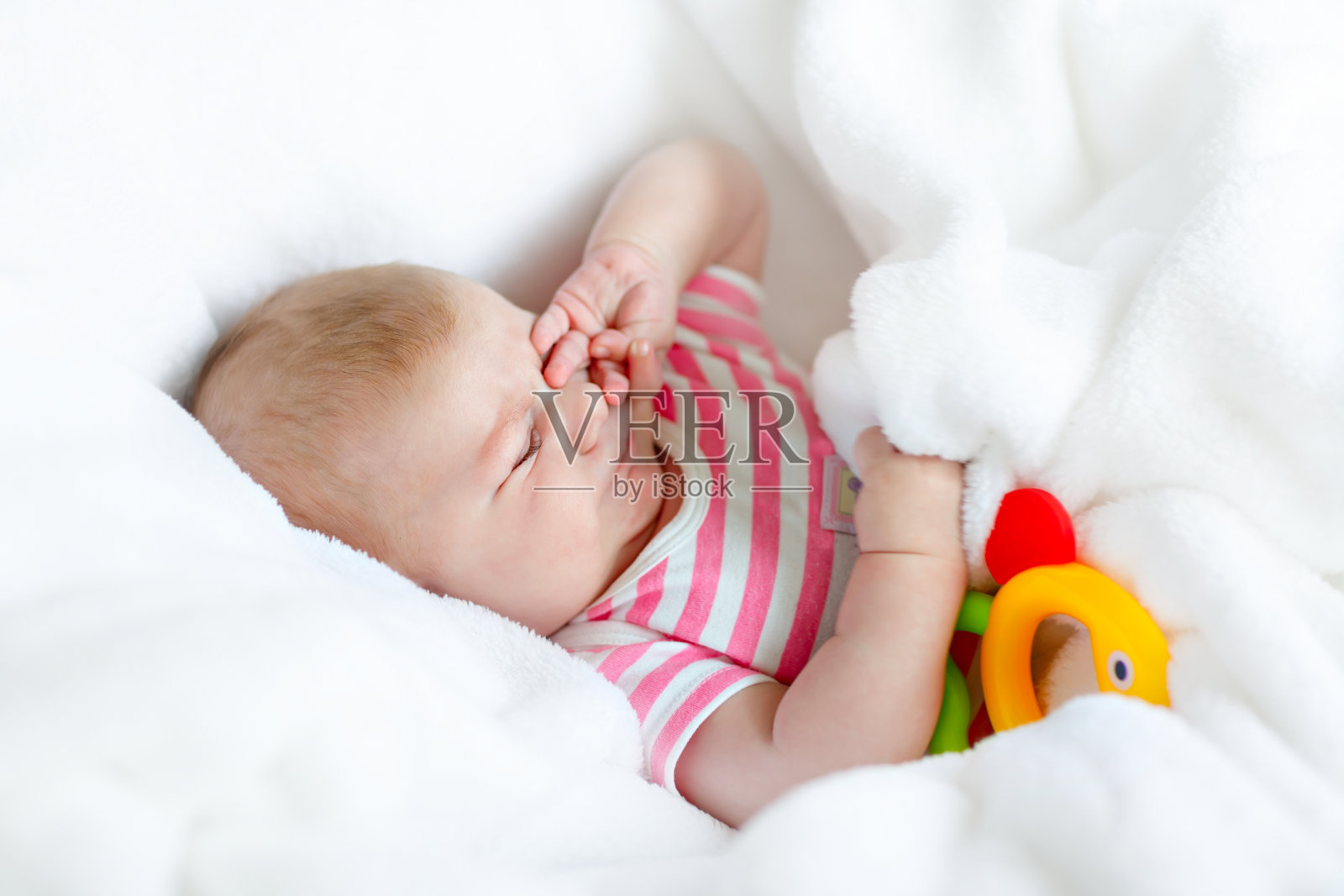 可爱可爱的两个月宝宝吮着拳头。照片摄影图片