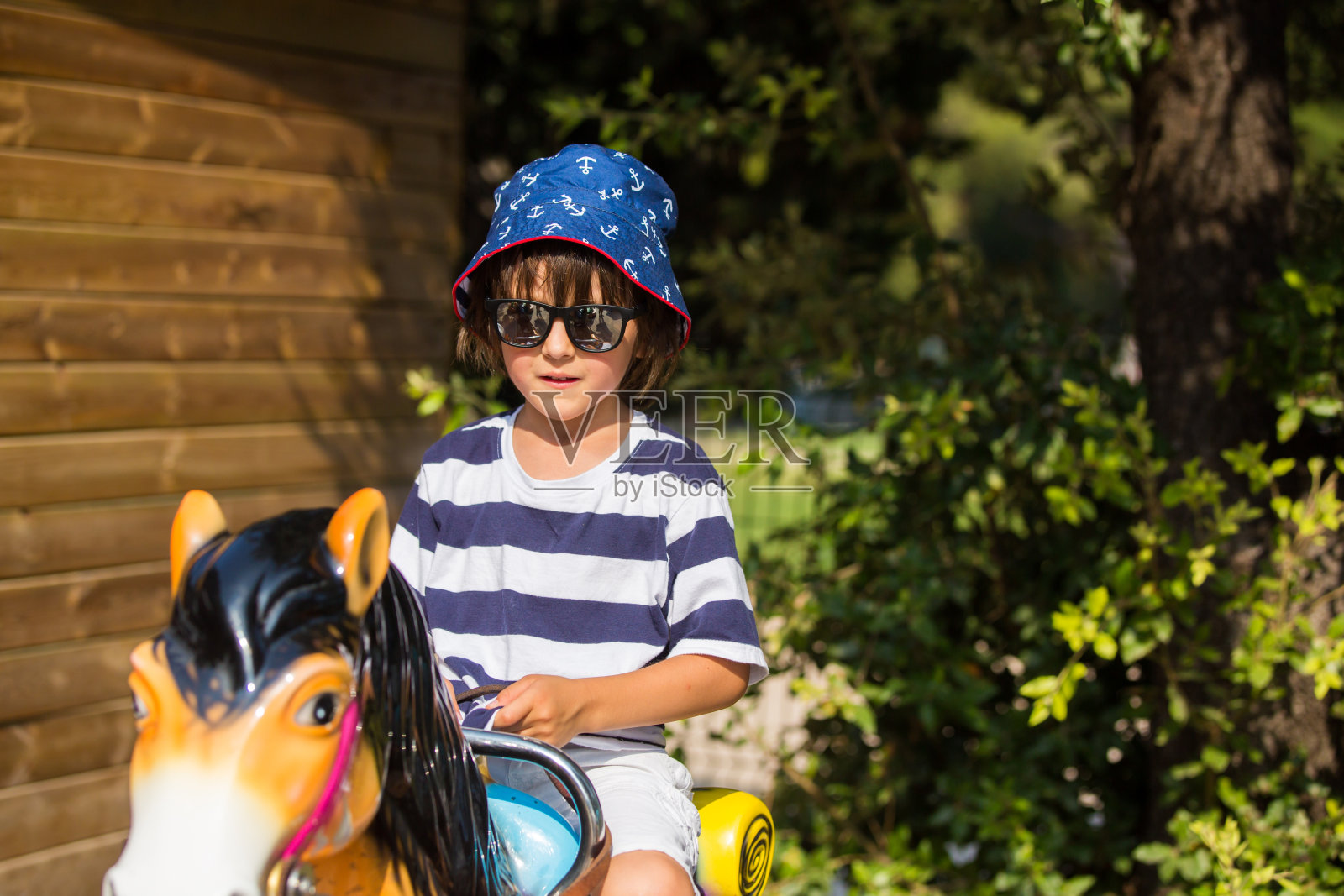 可爱的小孩，在游乐场骑马，夏天的户外照片摄影图片