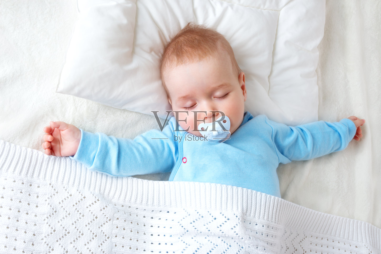 婴儿睡在蓝色的毯子上照片摄影图片