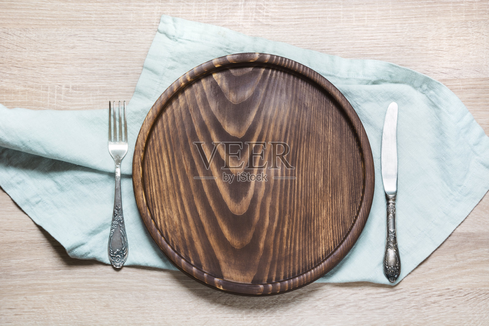 质朴的桌子，木制的盘子和餐巾在木制的桌面上。前视图。图像与复制空间。照片摄影图片