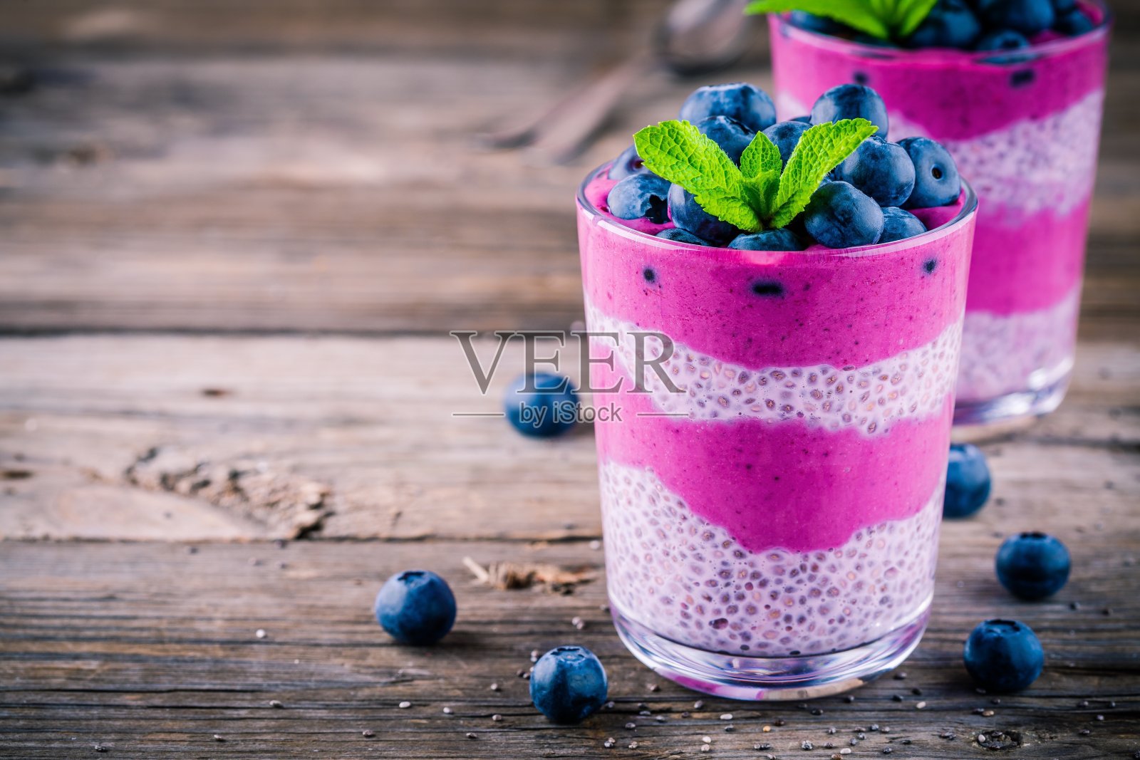 蓝莓冰沙与奇亚布丁玻璃杯与新鲜浆果和薄荷照片摄影图片