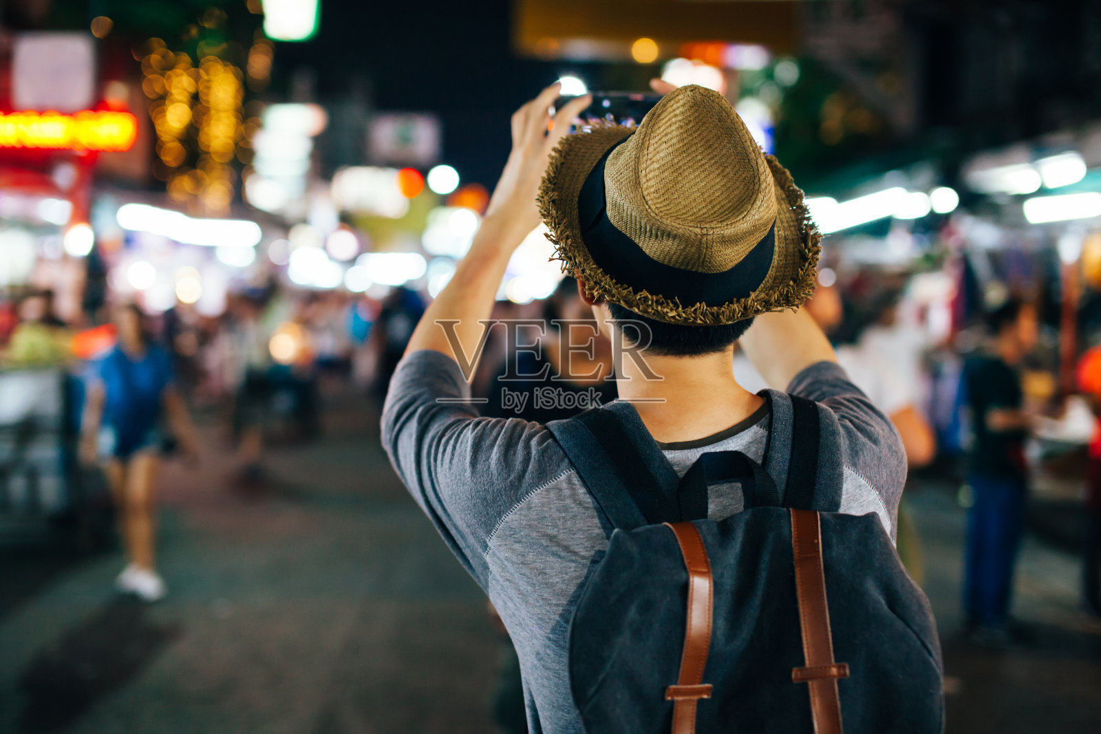 年轻的亚洲旅行者在夜晚的街道上用手机拍照照片摄影图片