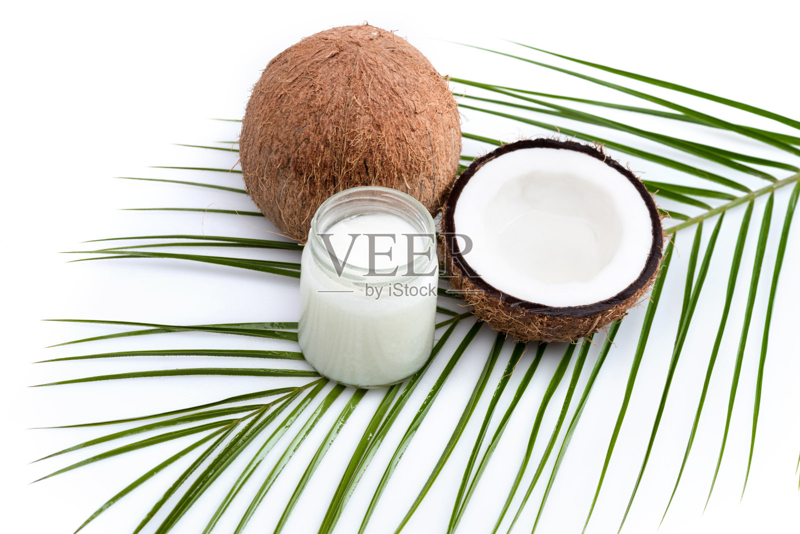 成熟椰子和有机椰子油在玻璃瓶上椰子叶孤立白色照片摄影图片