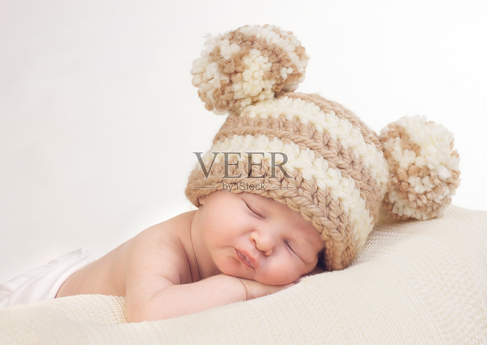 熟睡的新生儿编织绒球帽照片摄影图片