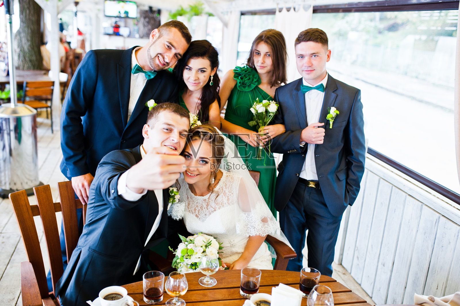 新婚夫妇和伴郎的快乐朋友和伴娘在咖啡厅自拍照片摄影图片