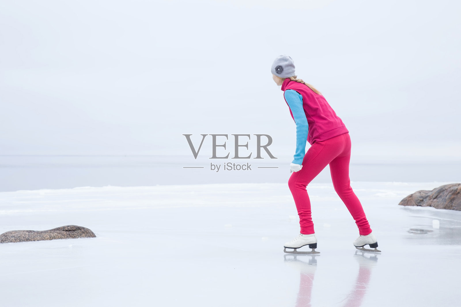 女子滑冰和训练与白色冰鞋。周末户外活动。照片摄影图片