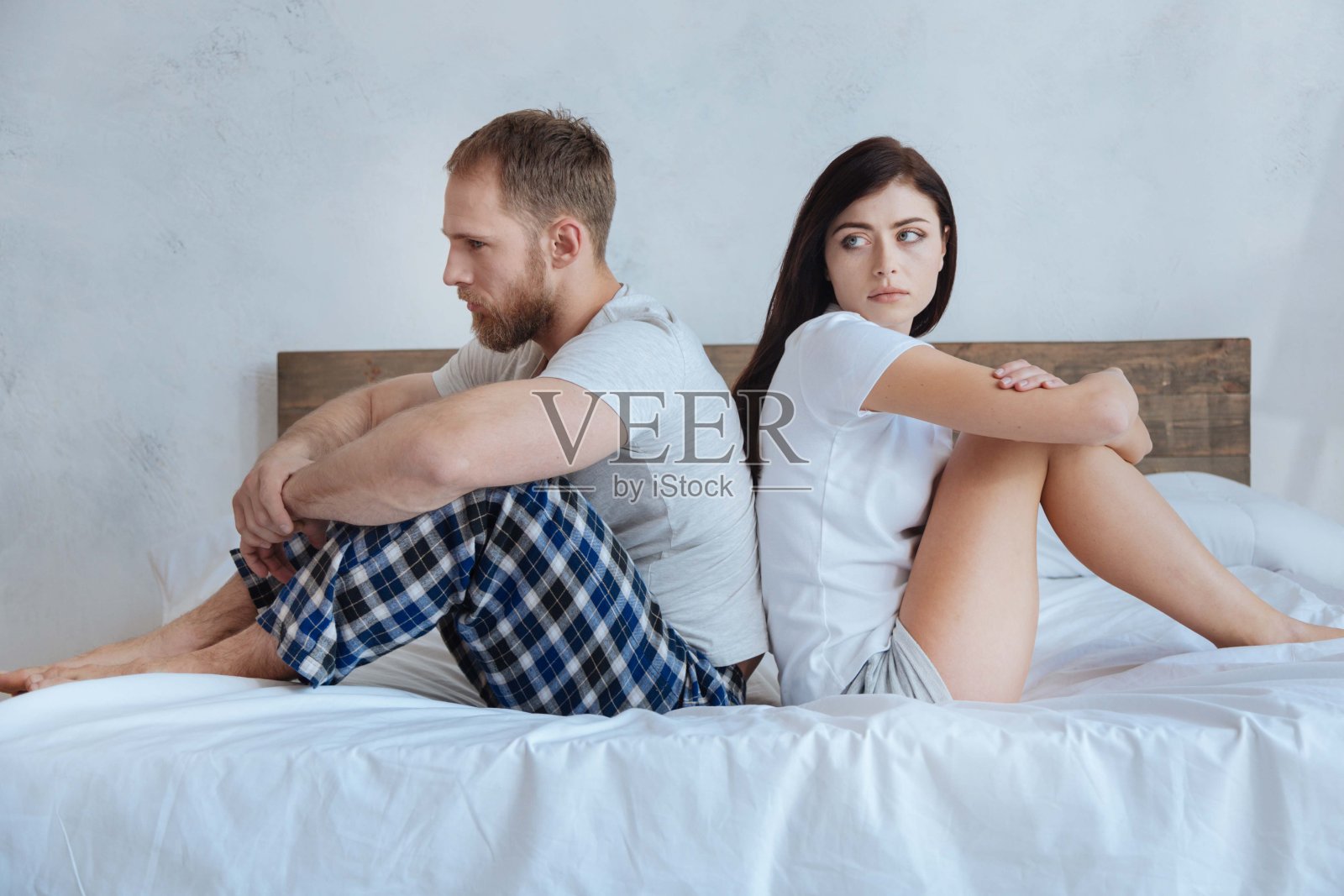 一对千禧夫妇吵架后坐在床上照片摄影图片