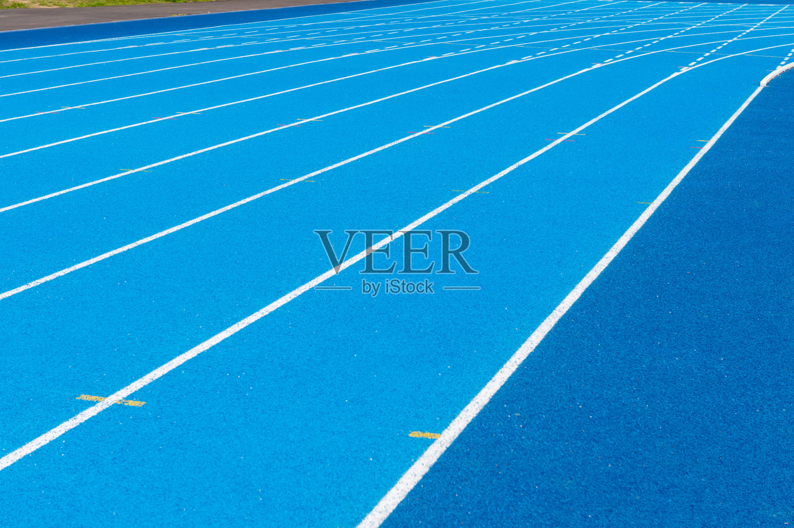 蓝色跑道。一条条蓝色跑道。户外体育场内有蓝色沥青和白色标记的跑道。有选择性的重点。照片摄影图片