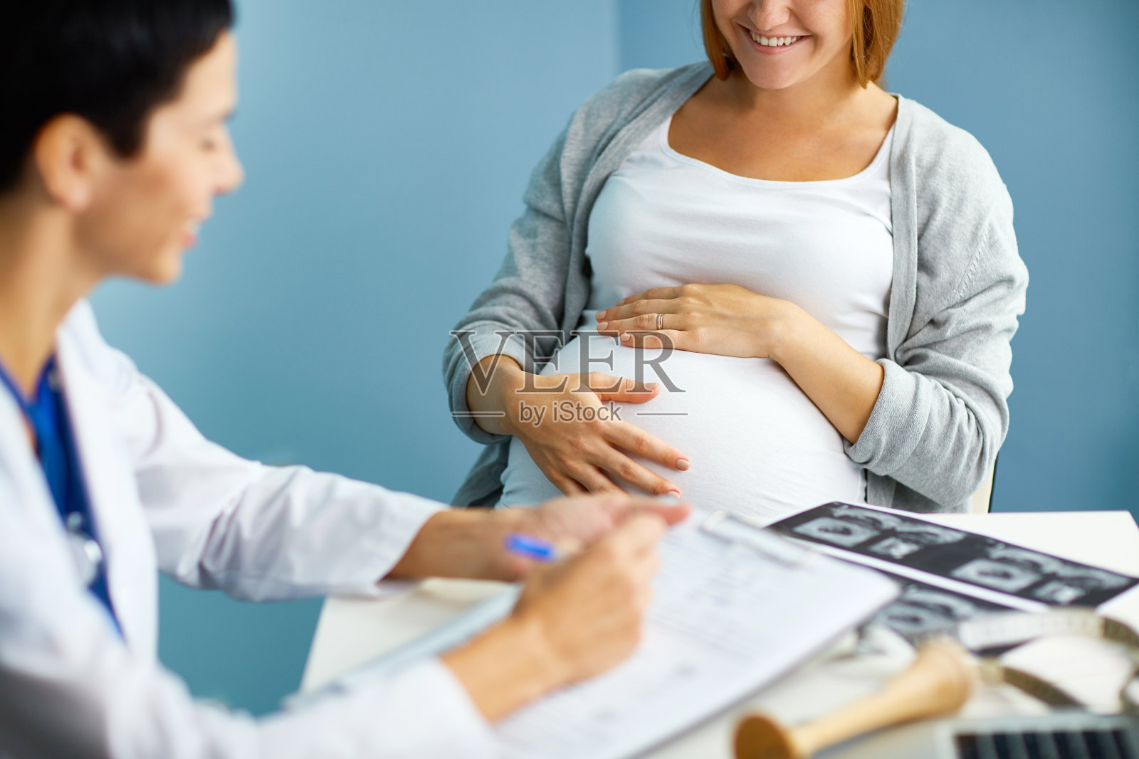 快乐的孕妇在妇科医生办公室照片摄影图片