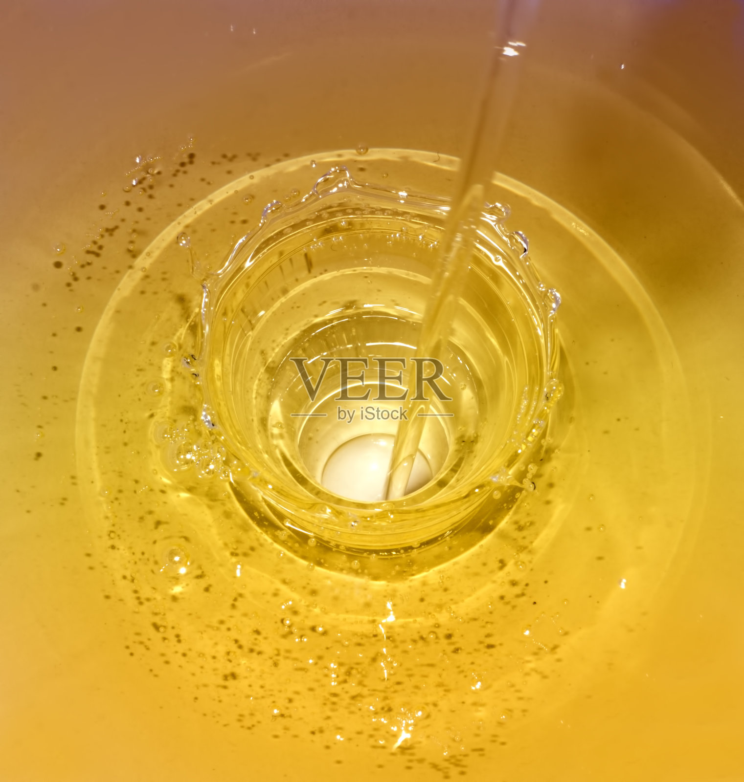 金色的液体被倒入一个洞中照片摄影图片