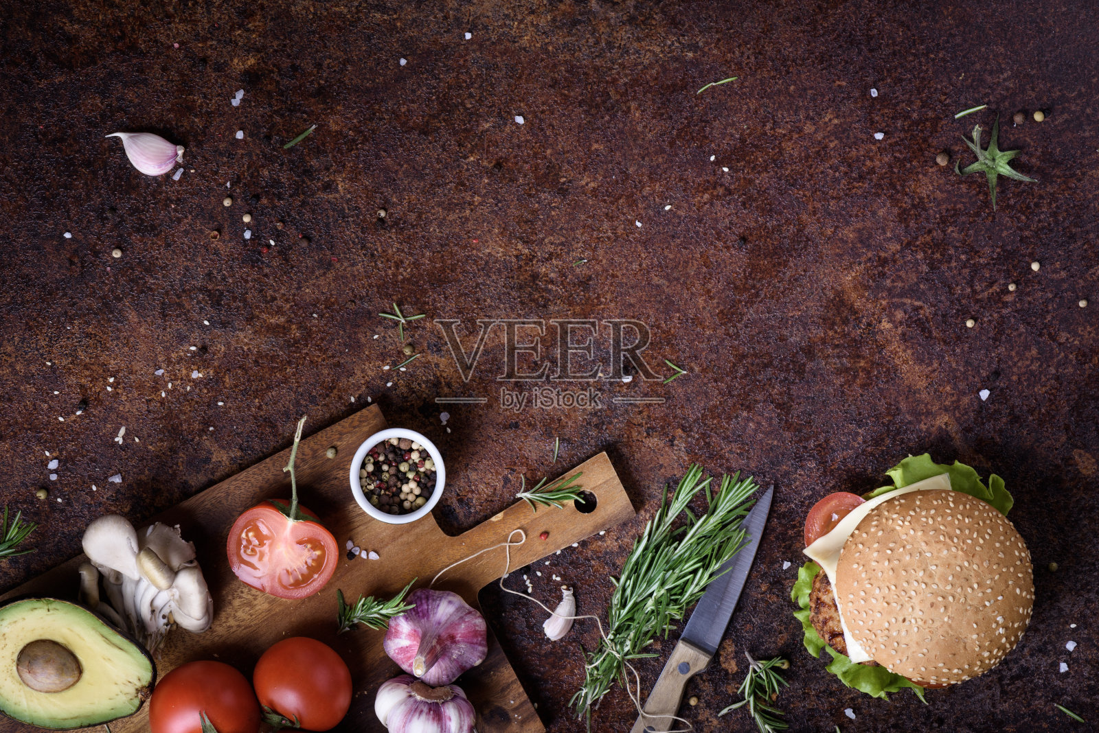美味的芝士汉堡，有牛肉馅饼，奶酪，新鲜的莴苣，蘑菇和西红柿，新鲜的面包和芝麻在一个乡村的桌面上。照片摄影图片