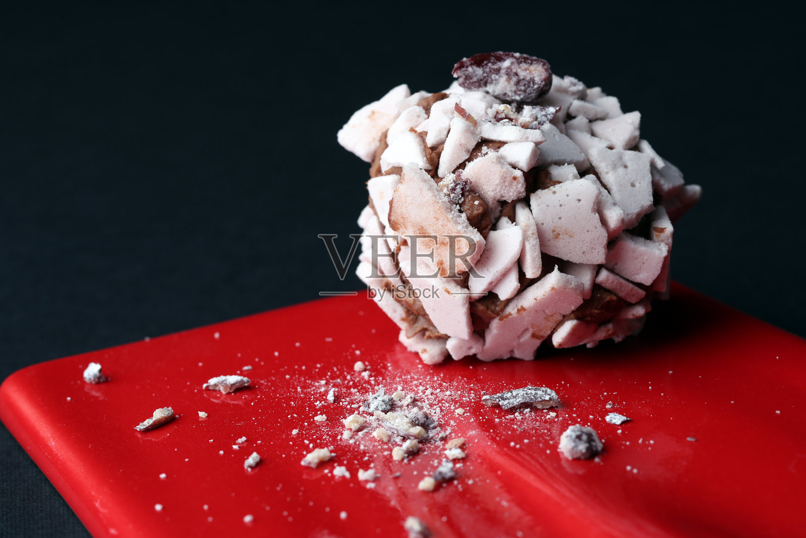 甜的甜点。美味的蛋白酥皮放在红色的盘子上，黑色的背景照片摄影图片