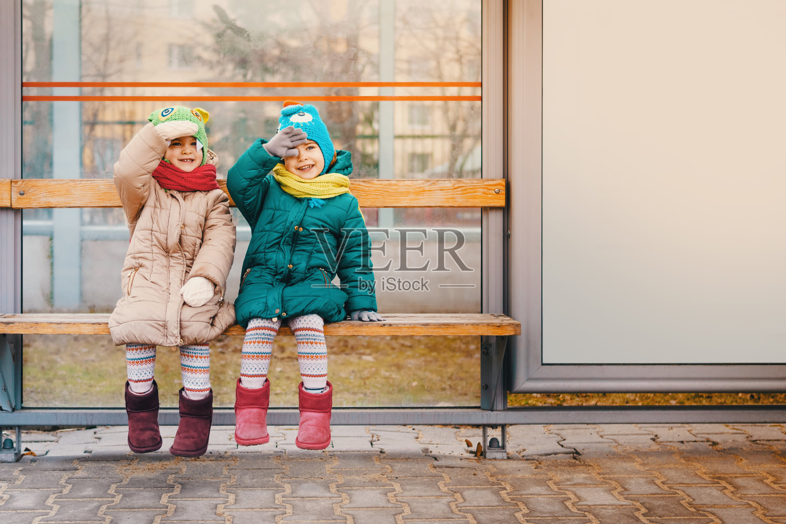 两个女孩坐在公共汽车站照片摄影图片