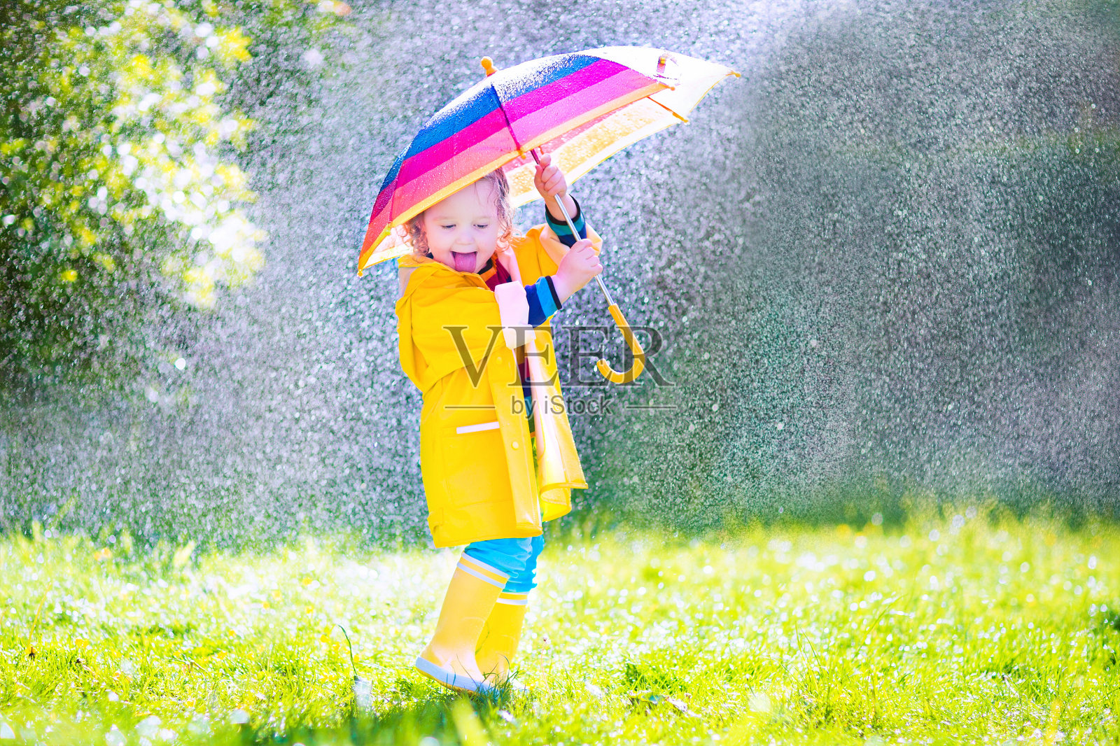 漂亮有趣的小孩拿着伞在雨中玩耍照片摄影图片