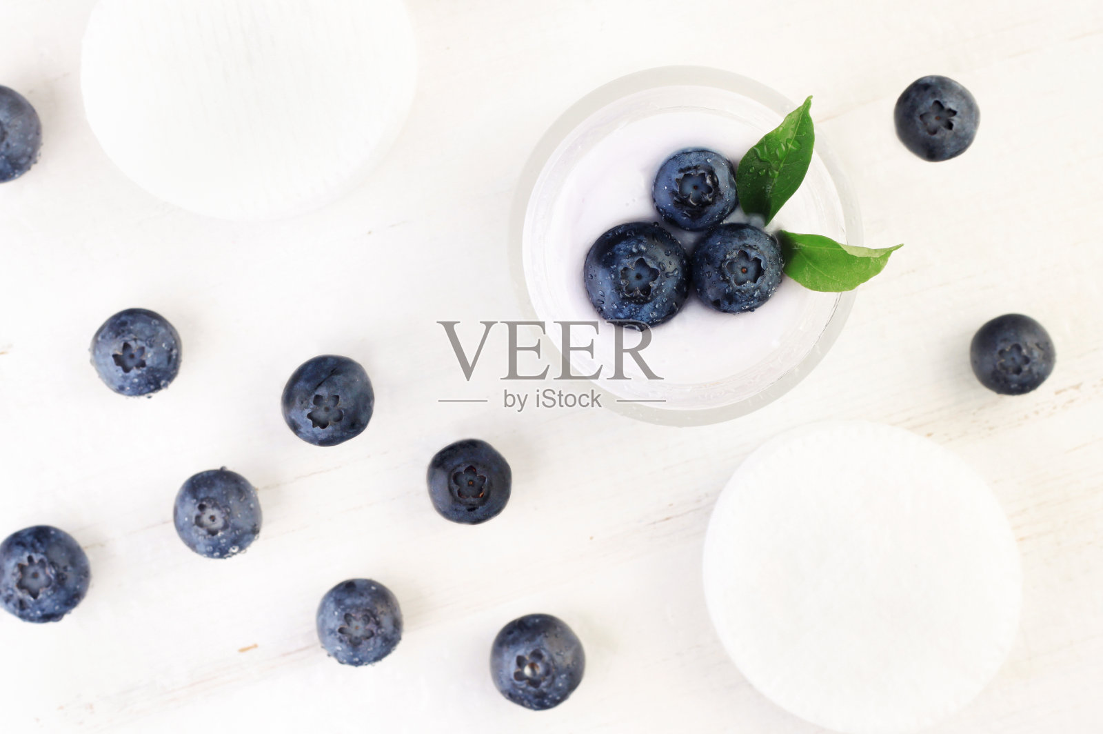 蓝莓面霜在罐子与新鲜浆果分散白色木质背景，俯视图。照片摄影图片