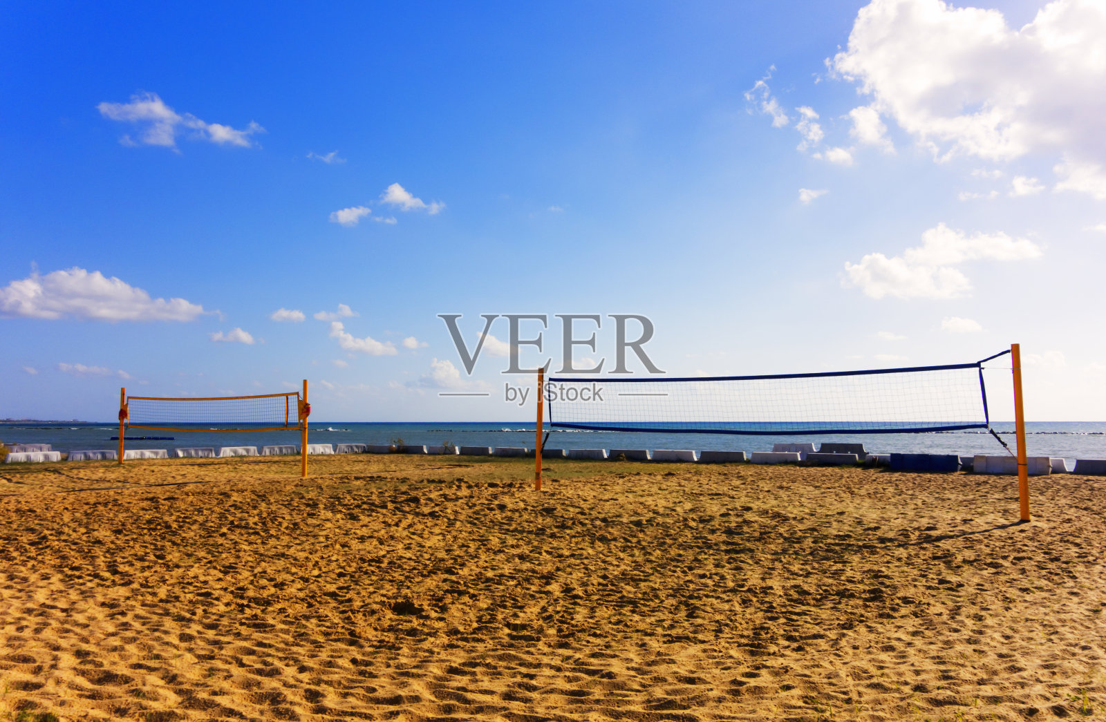 沙滩上的排球网迎着大海和蓝天。照片摄影图片
