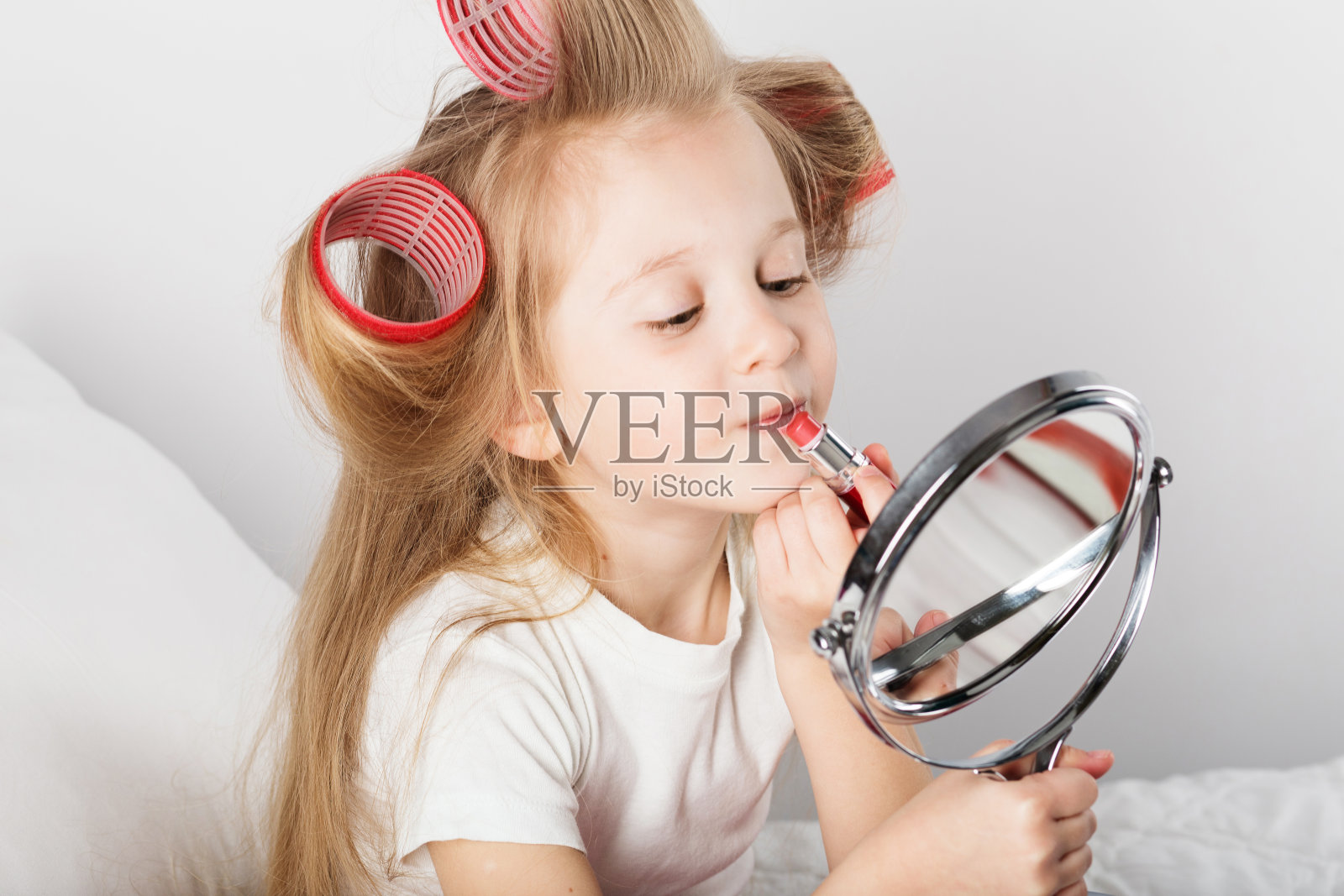 时尚小女孩用镜子化妆。照片摄影图片
