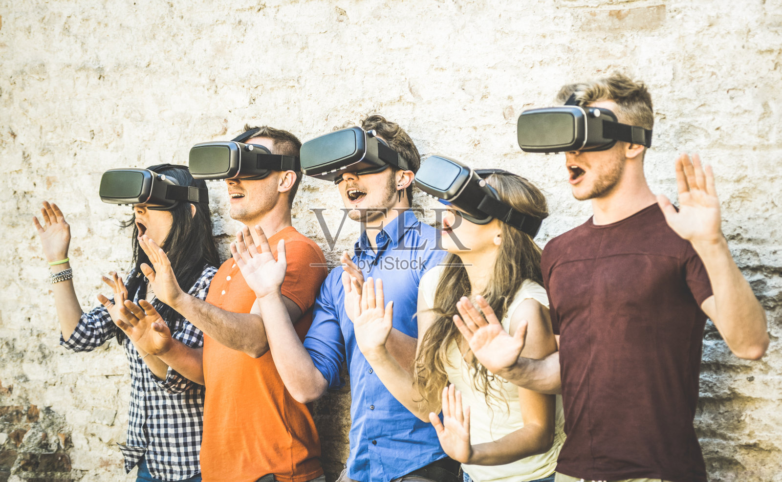 朋友群玩虚拟现实眼镜户外-虚拟现实和可穿戴的技术概念与年轻人有乐趣与耳机护目镜-数字一代趋势-复古对比滤镜照片摄影图片
