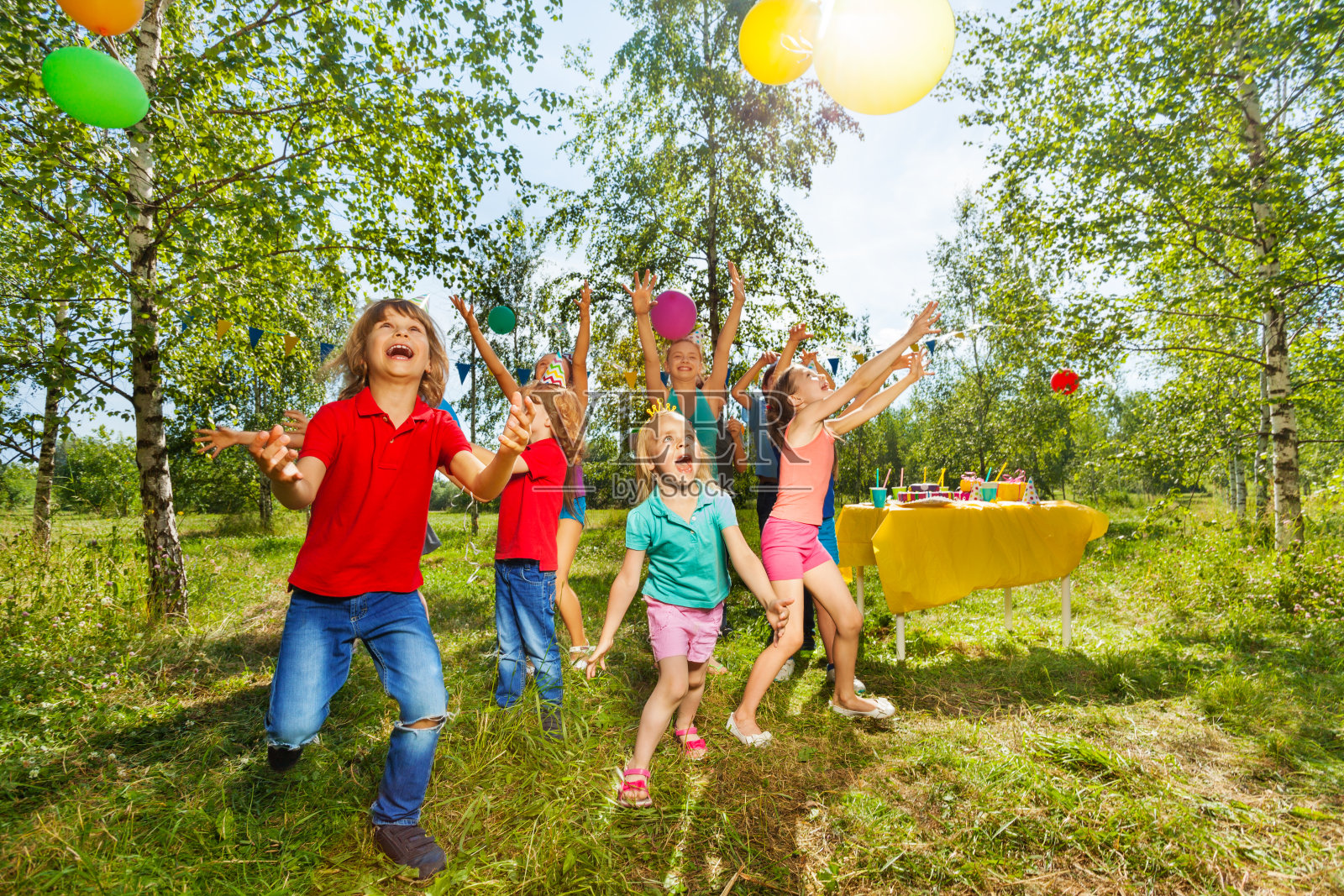 快乐的孩子们在夏天的公园里玩气球照片摄影图片