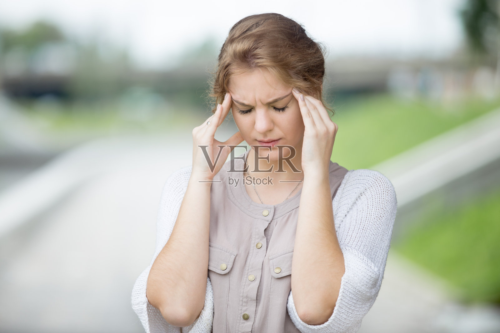 这是一幅饱受压力的妇女在户外头痛的画像照片摄影图片