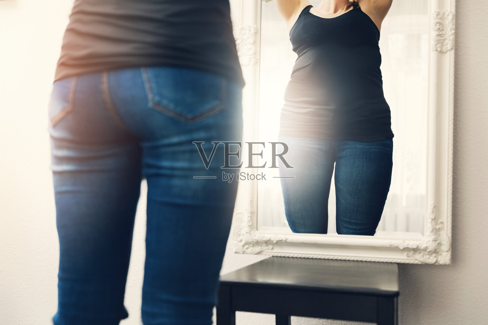 厌食症的概念——女人看着镜子里自己肥胖的倒影照片摄影图片