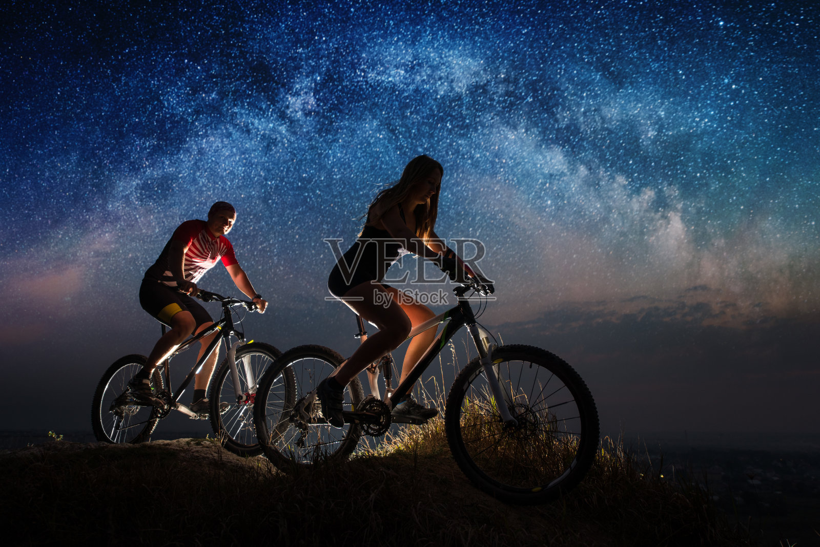 一对运动情侣在星空下骑自行车照片摄影图片