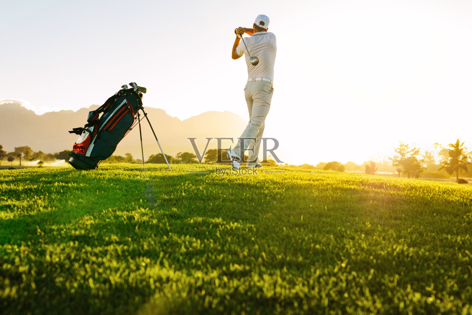 在高尔夫球场上击球的职业高尔夫球手照片摄影图片