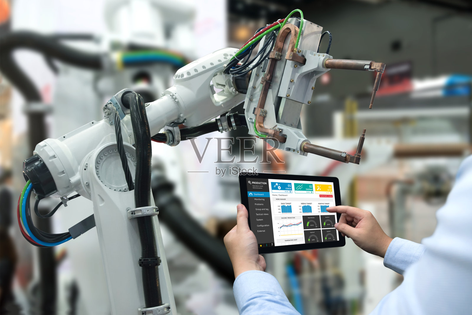 工程师手用平板，重型自动化机器人手臂机器在智能工厂工业用平板实时监控系统中的应用。工业第四物联网概念。照片摄影图片