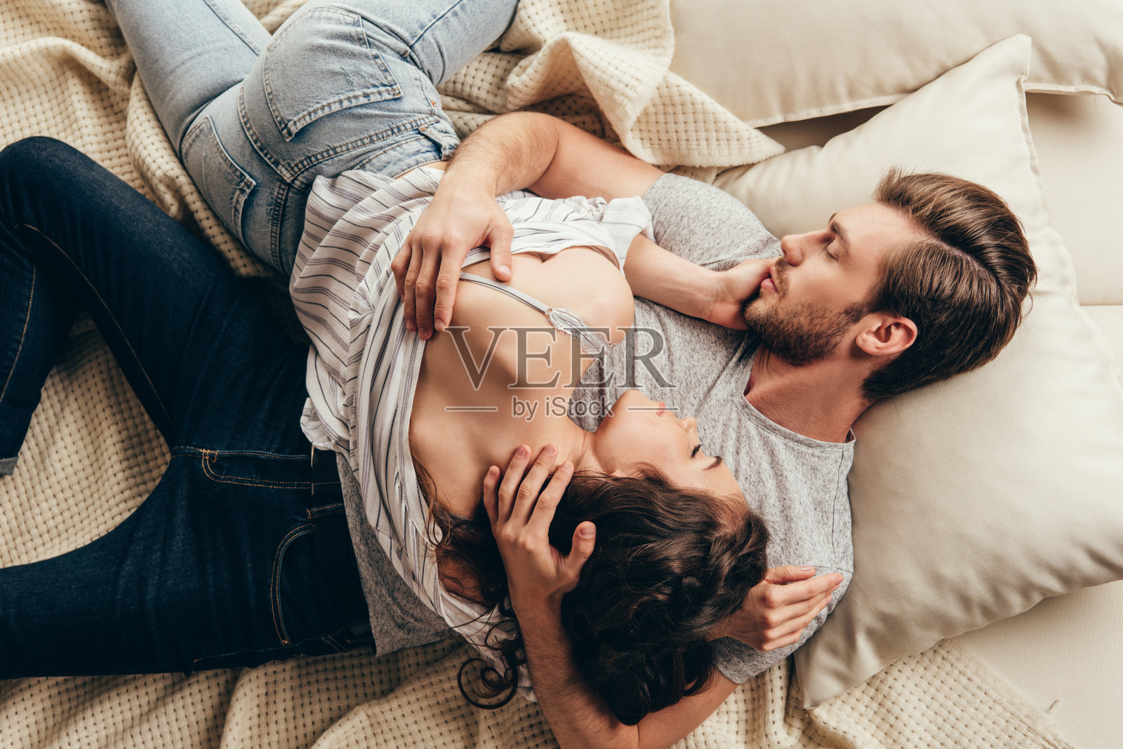 高角度的美丽的年轻夫妇在床上相爱的拥抱照片摄影图片