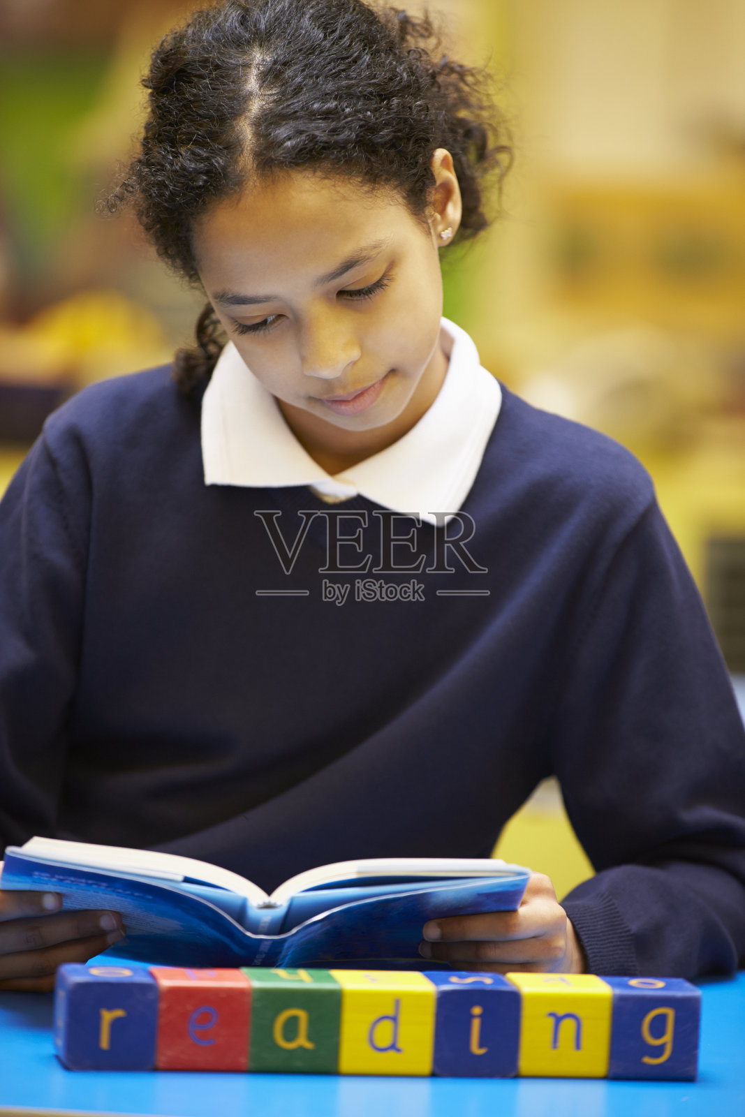 单词“Reading”拼写在木块上，学生在后面照片摄影图片