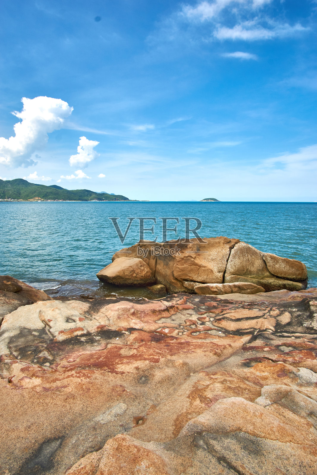 垂直拍摄的大海与戏剧性的天空和岩石在前景- Hon Chong -在芽庄，越南。照片摄影图片